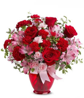 Red and pink roses with a bow in a red vase