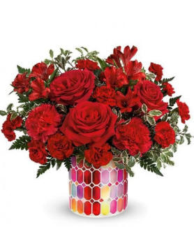 red roses, carnations and greenery iin a mosaic vase