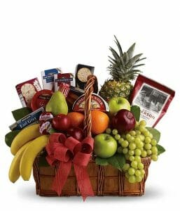 A gift basket filled with various fruit, snacks and gourmet foods.