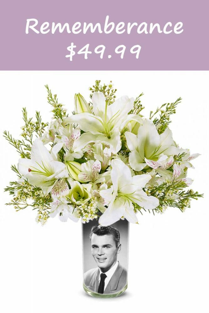 Rememberance vase with am image of the loved one inside a clear vase visable for all to enjoy, treasure and love to celebrate the life of a lost loved one. White flowers and white lilies.
